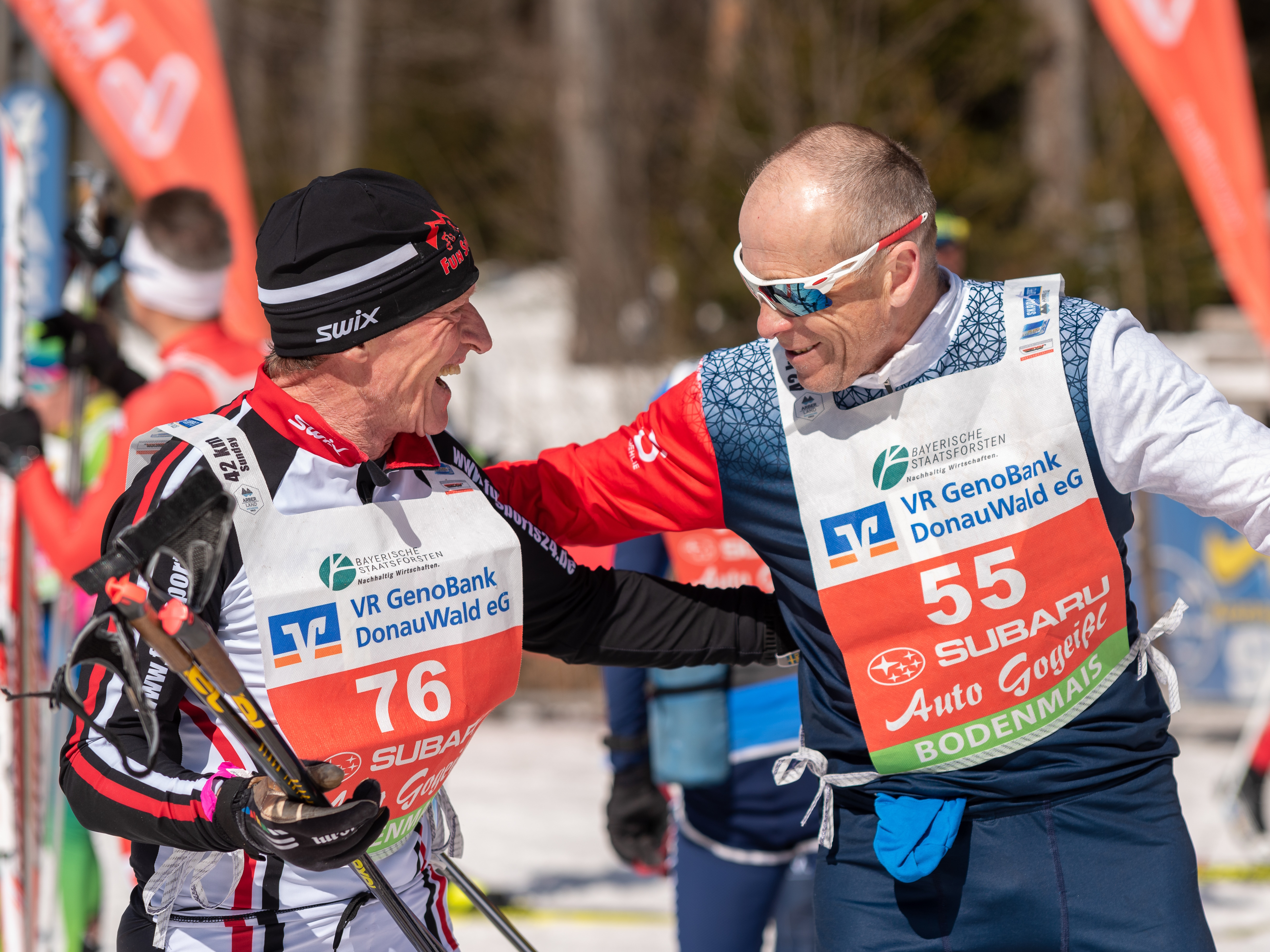 Zwei ältere Skimarathonläufer gegrüßen sioch freundlich bei Sonnenschein