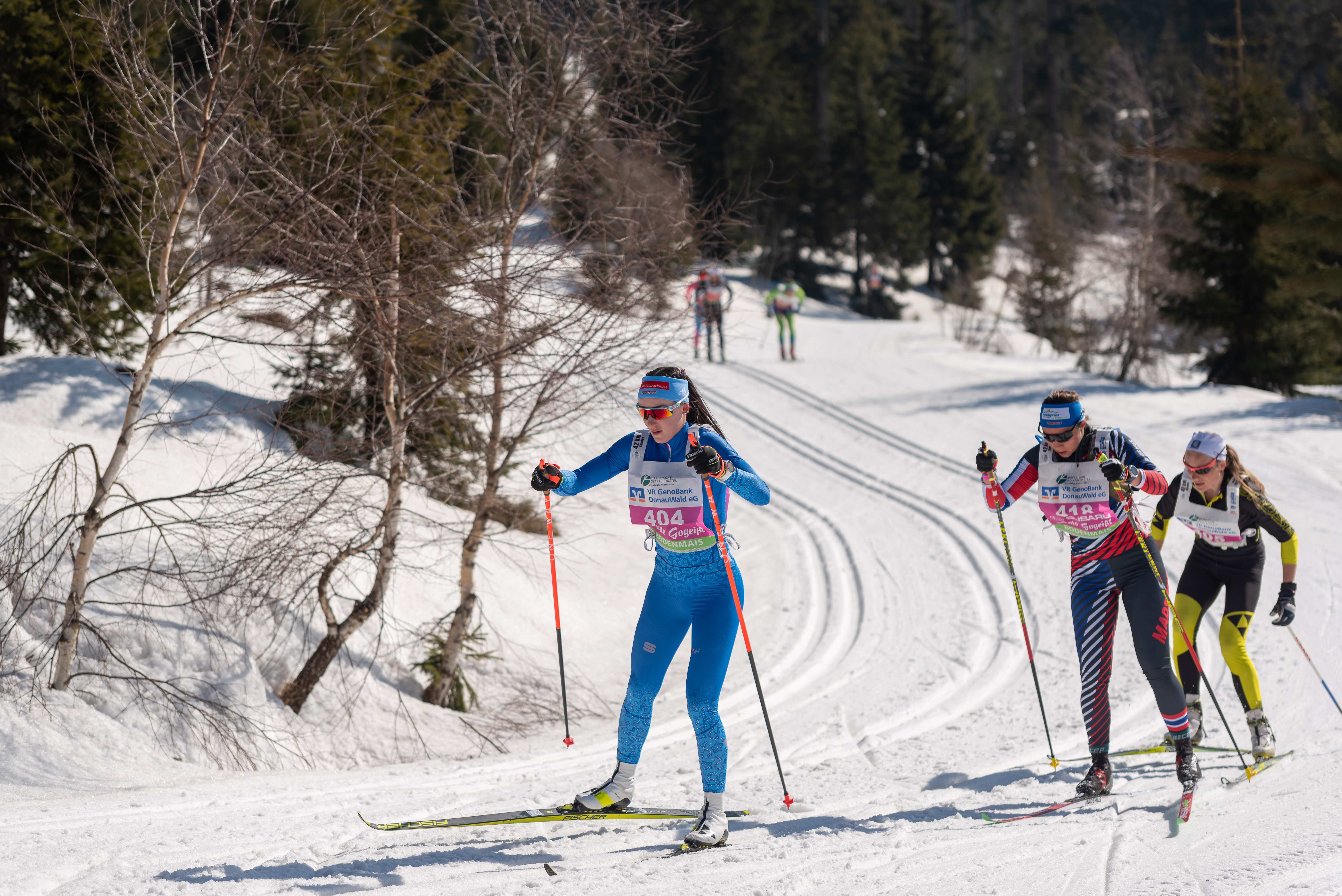 Drei Skimarathonläuferinnen laufen bei Perfekten BEdingungen um eine Kurve