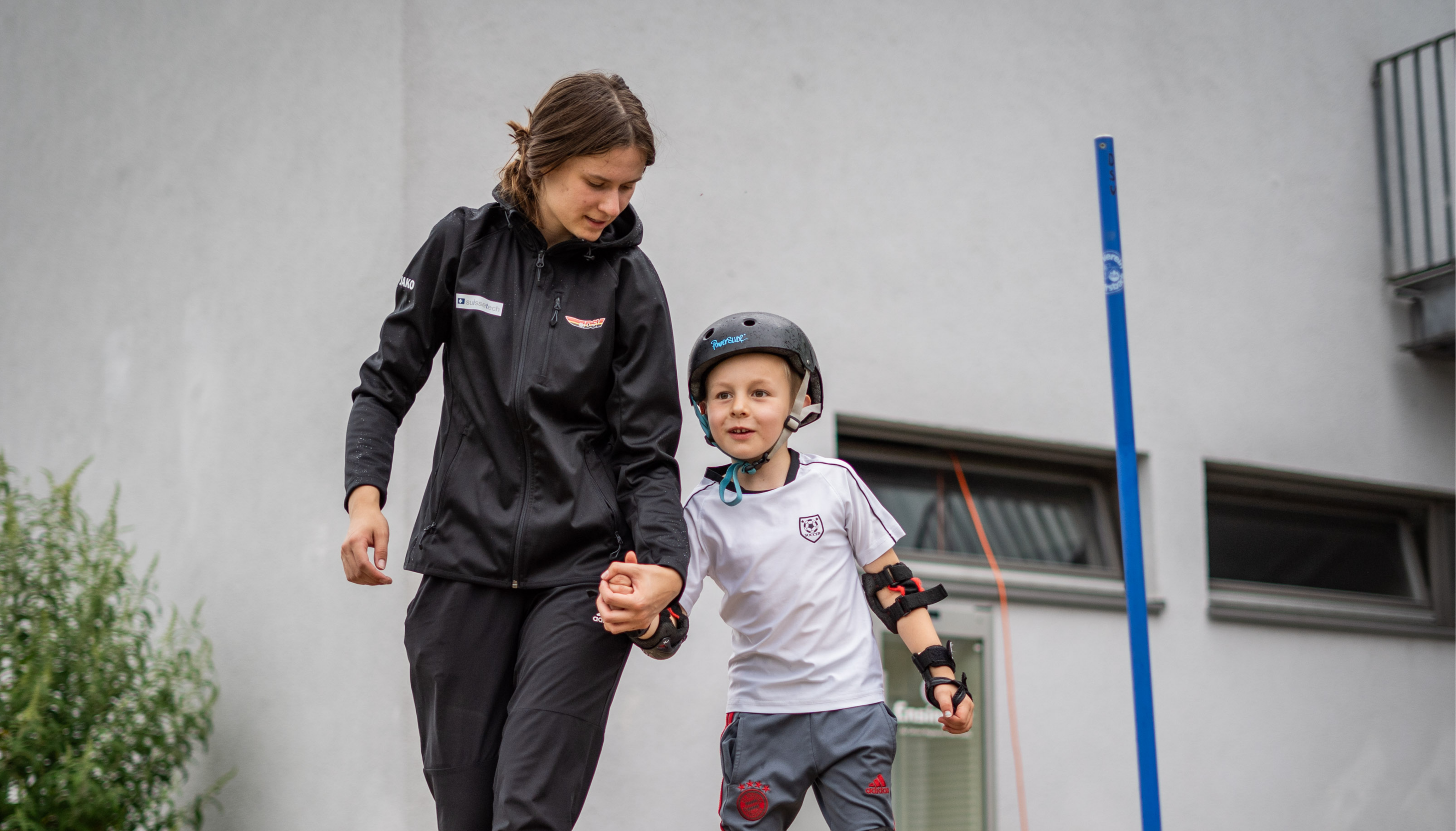 Eventteamerin unterstützt Jungen auf Inlinern